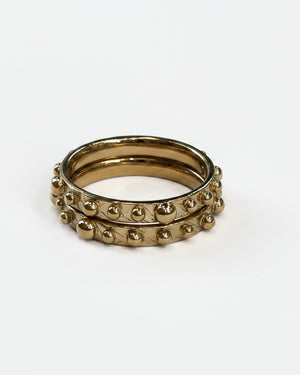 Two gold rings with beaded designs on a white background