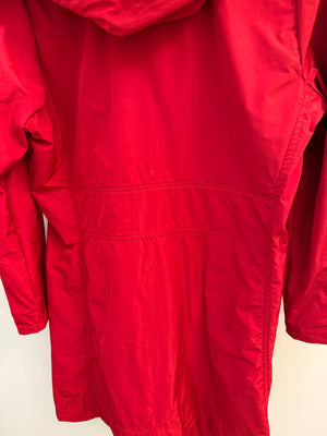 A close-up of a bright red hooded jacket or coat, showing the fabric texture, seams, and hood attachment against a plain light background.