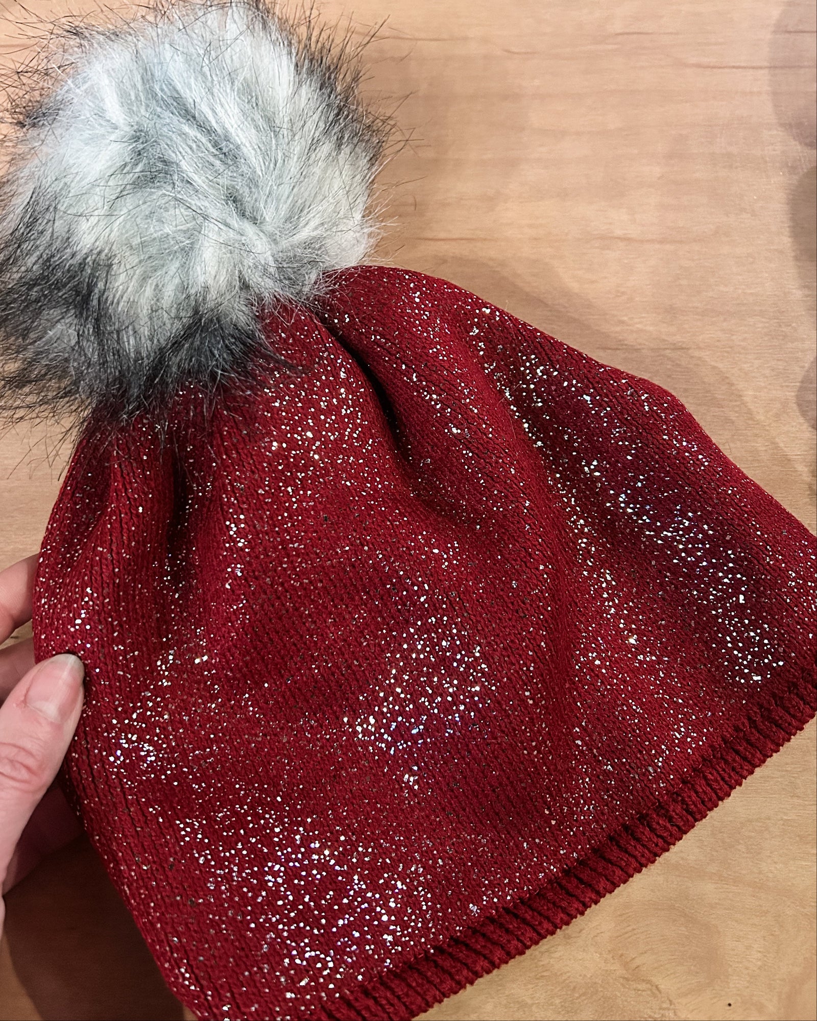 Black beanie with a fur pom-pom on a white background