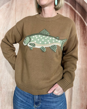 Person wearing a brown sweater with a fish design against a neutral background