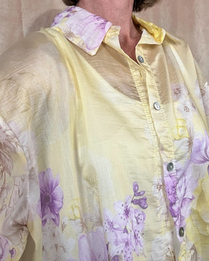 Yellow floral blouse worn by a person on a plain background