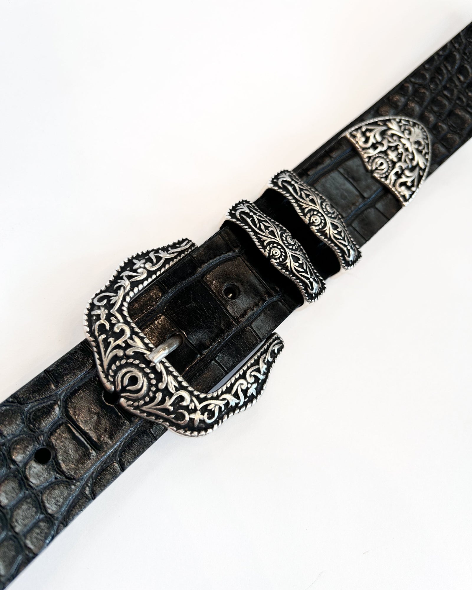 Black leather belt with silver buckle on a white background