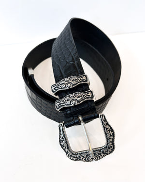 Black belt with decorative silver buckle on a white background