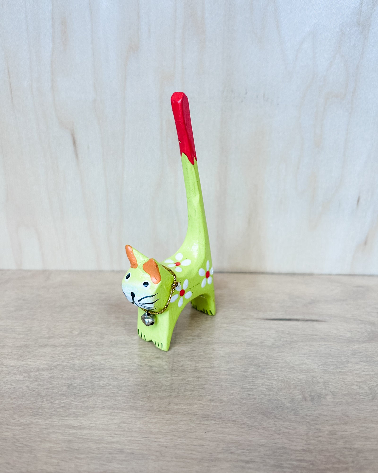 Cat-shaped jewelry holder with rings on a wooden surface