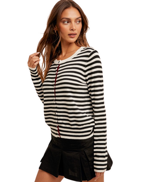 Woman wearing a black and white striped sweater with a white background