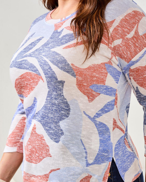 Person wearing a floral-patterned cardigan with red and blue flowers on a plain background