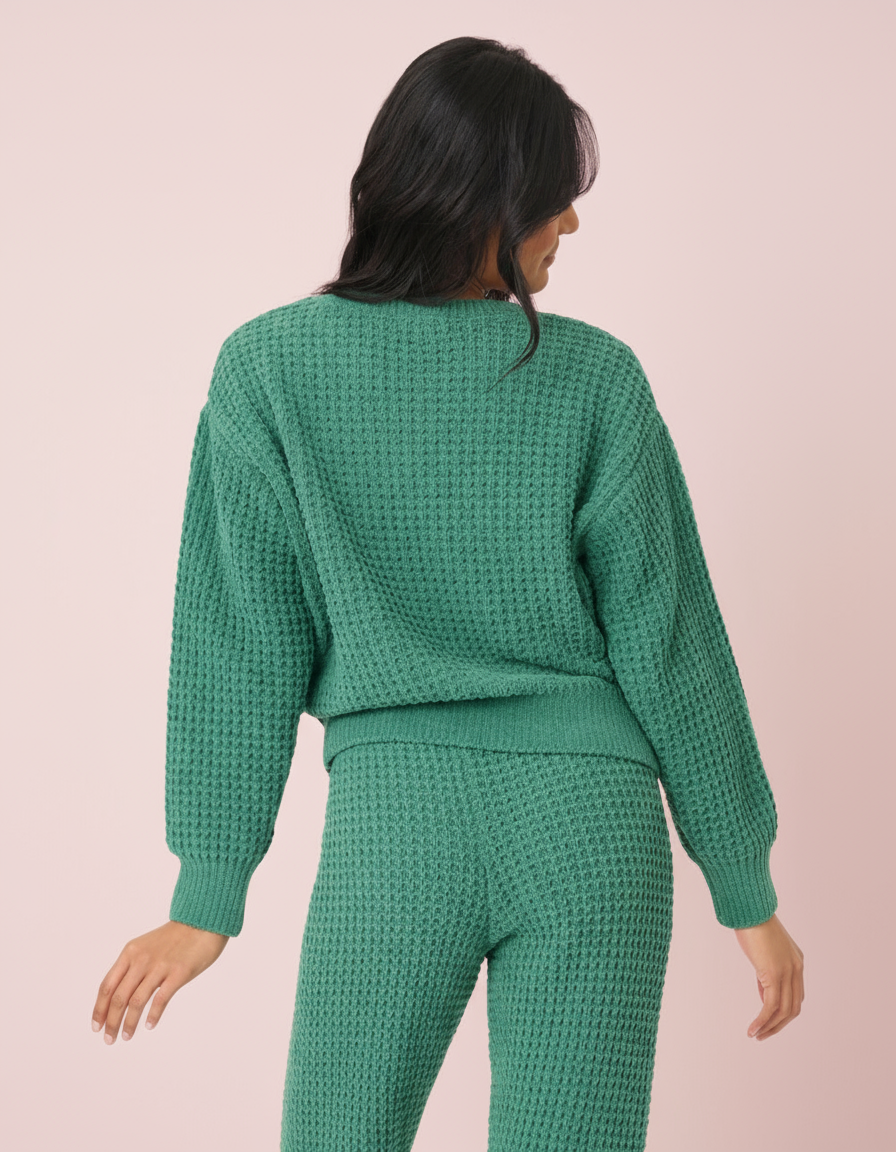 Woman wearing a green waffle knit pajama set on a white background