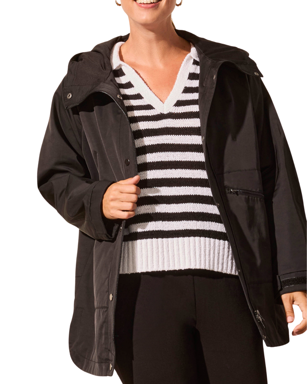 Person wearing a black jacket over a striped sweater on a white background