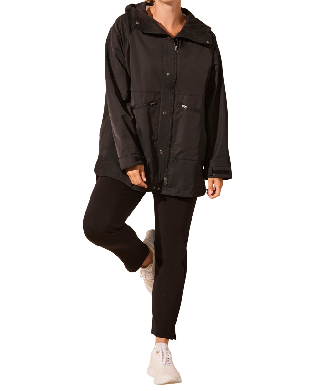 Person wearing a black jacket over a striped sweater on a white background