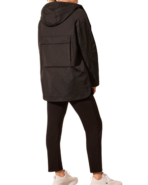 Person wearing a black hooded jacket and pants on a white background