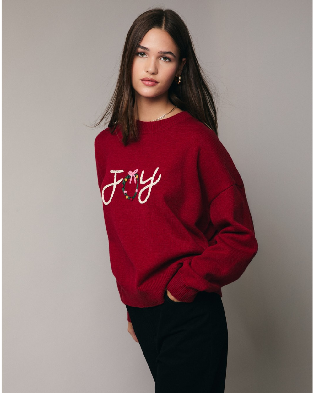 Red sweater with 'JOY' and a wreath design on a plain background