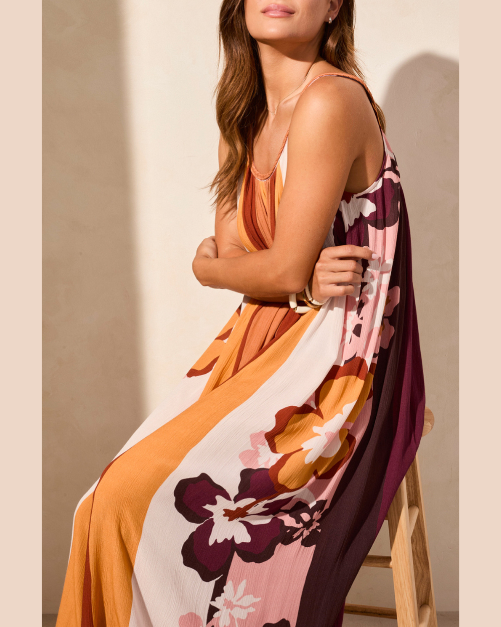 Woman wearing a long, patterned dress with a neutral background
