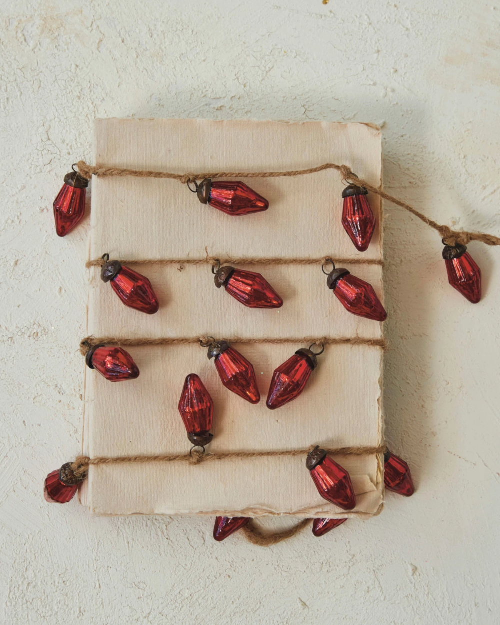 String of red Christmas lights on a beige fabric background