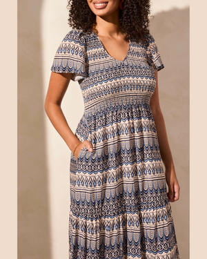 Woman wearing a patterned dress against a neutral background