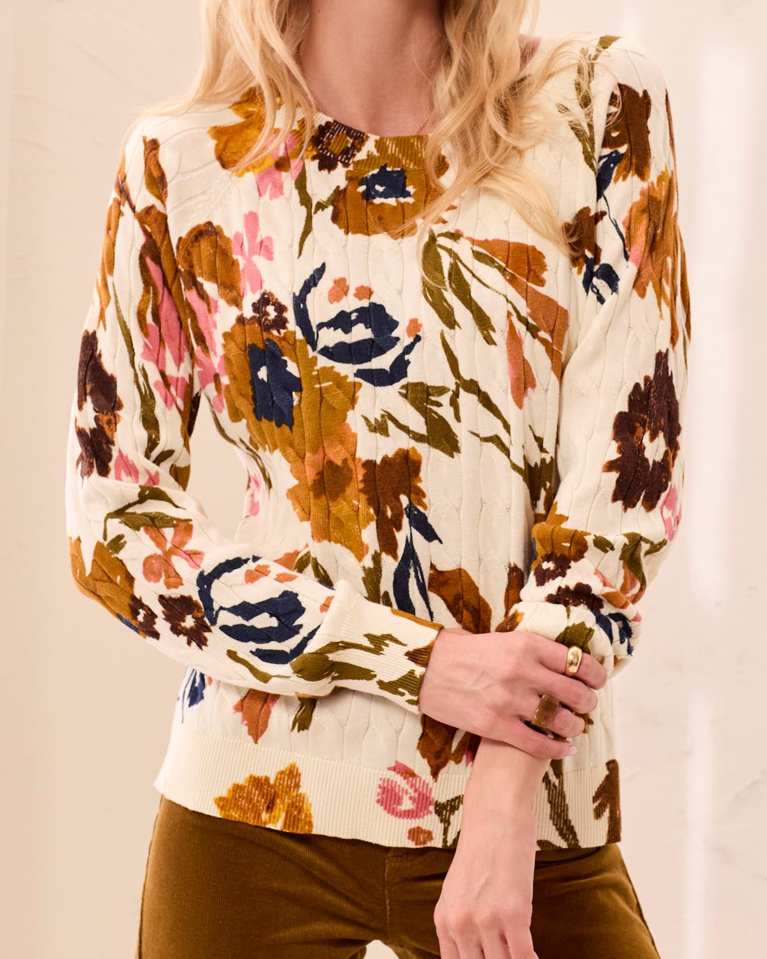 Woman wearing a floral blouse with a neutral background