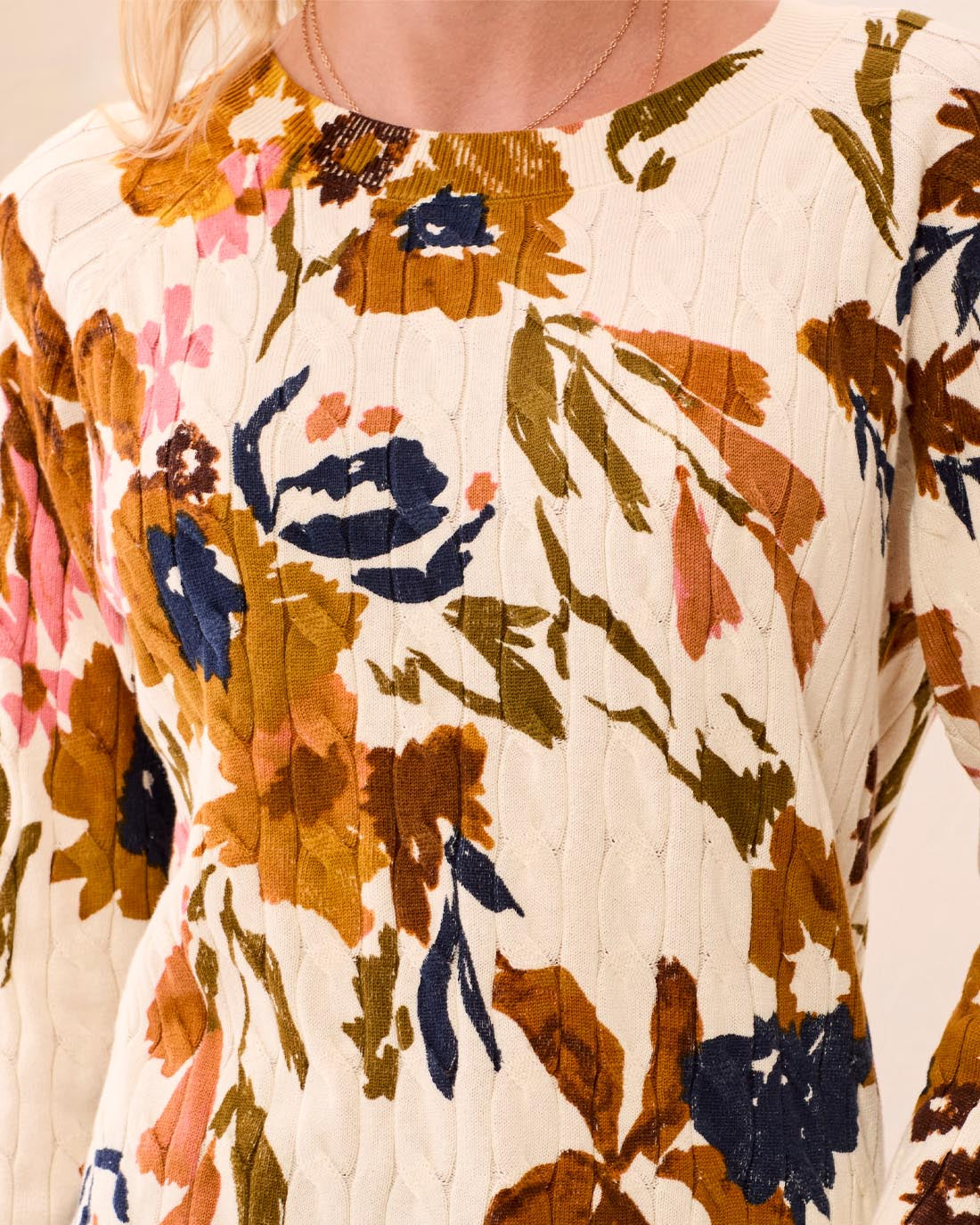 Woman wearing a floral blouse with a neutral background